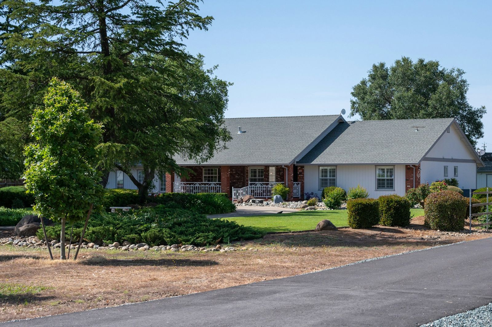 A single-story brick home with a front porch and lawn
